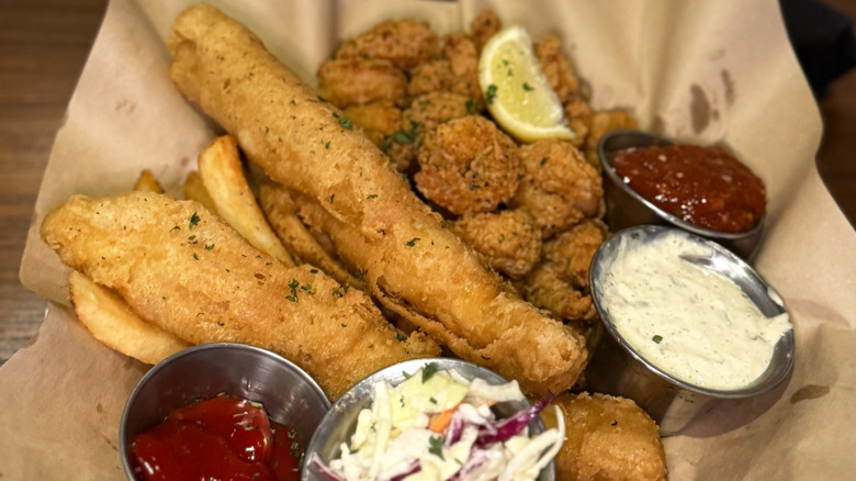 Battered cod and fried shrimp on a plate with ketchup and coleslaw from Bonefish Grill.