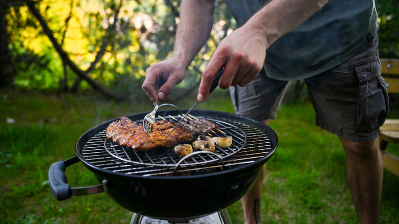 Person using a charcoal grill.