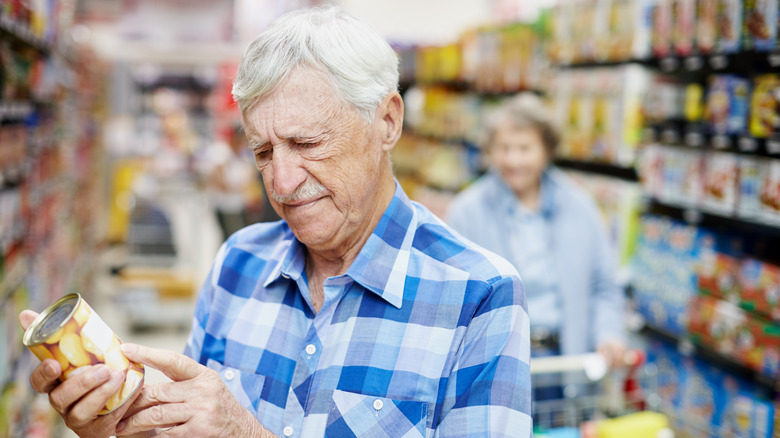 a man contemplates a can of food