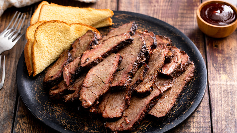 sliced brisket with toast on black plate