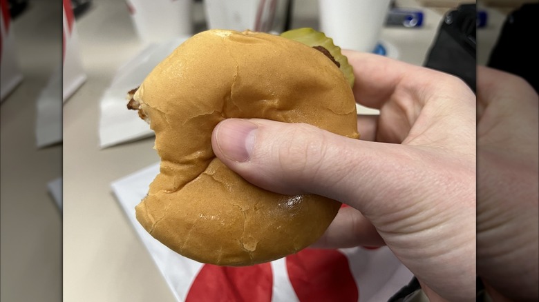 A hand holds a Chick-fil-A chicken sandwich.