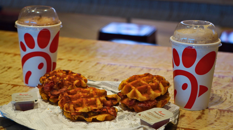 Side view of Chick-fil-A S'mores Frosted Coffee, S'mores Milkshake, and Chicken & Waffle Breakfast Sandwiches..