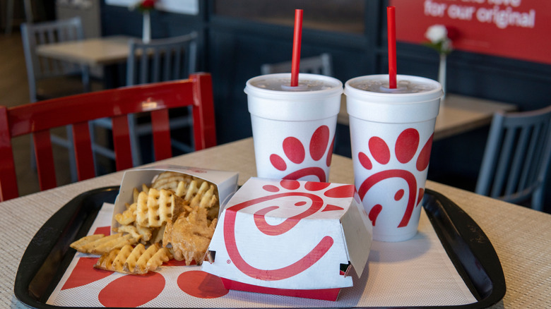 Chick-Fil-A fry cup, drink cup and sandwich box on a black tray