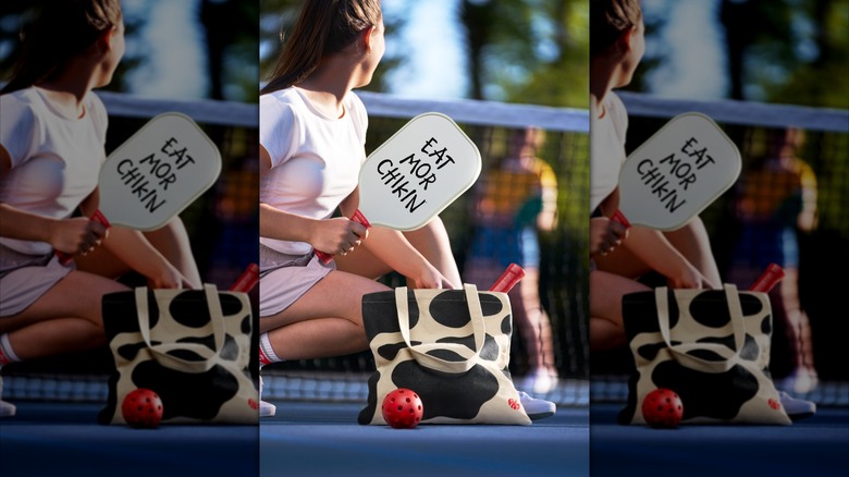 A woman uses the Eat Mor Chikin pickleball set