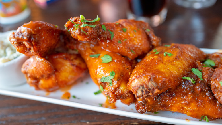 Closeup of a plate of buffalo chicken wings sprinkled with parsley