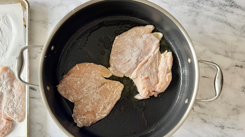 Butterflied chicken breasts in pan