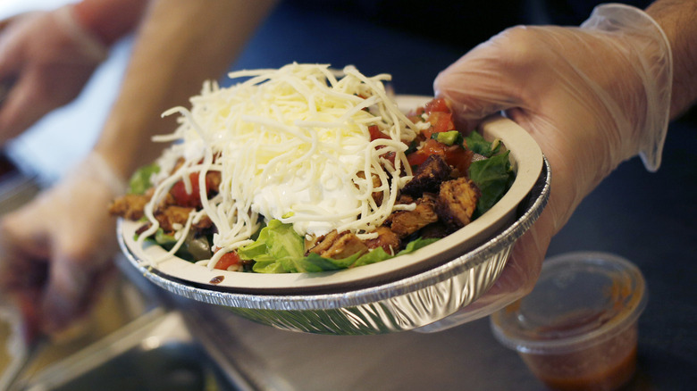 burrito bowl being prepped at chipotle restaurant