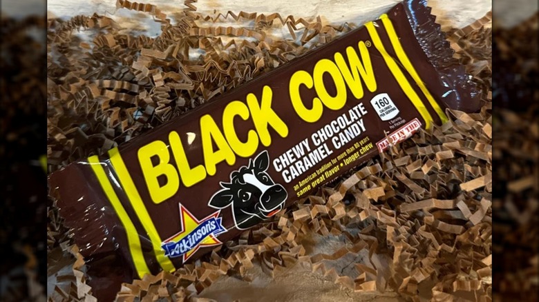A Black Cow bar sits on a pile of shredded brown paper