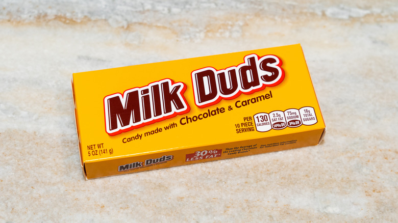 A box of Milk Duds sitting on a light-colored marble surface