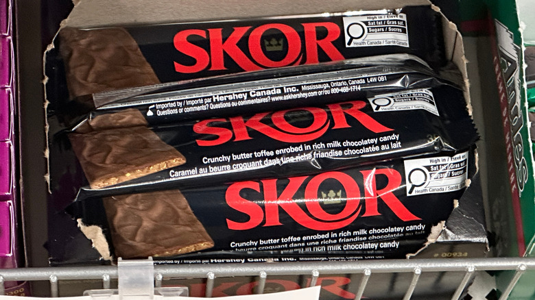 An open box of wrapped Skor bars sits on a retail shelf