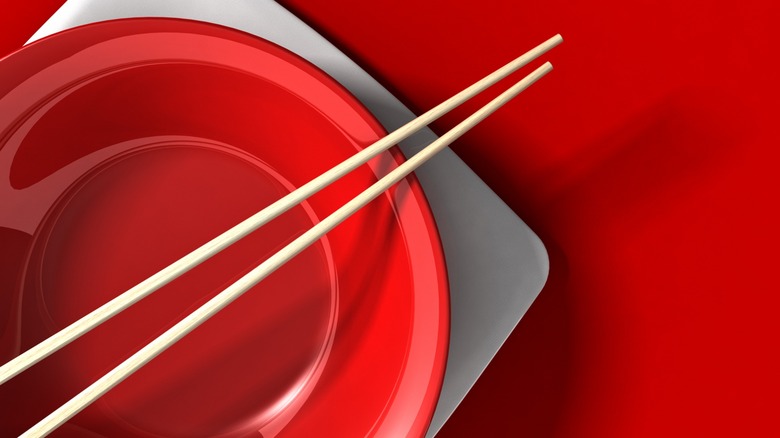 Chopsticks balanced on rim of a bowl