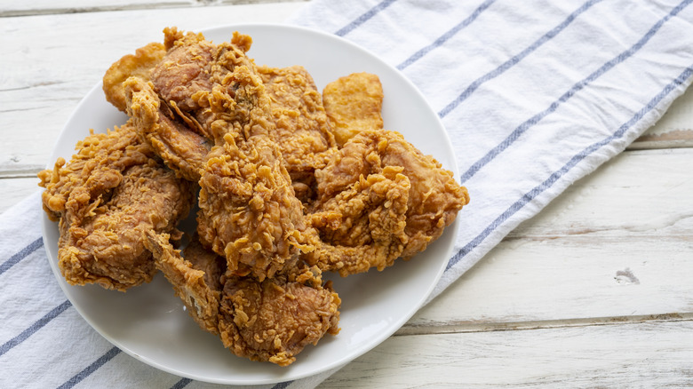 Plate of fried chicken on white table