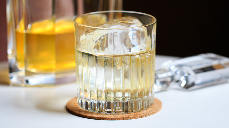 Clarified cocktail in rocks glass with large ice cube