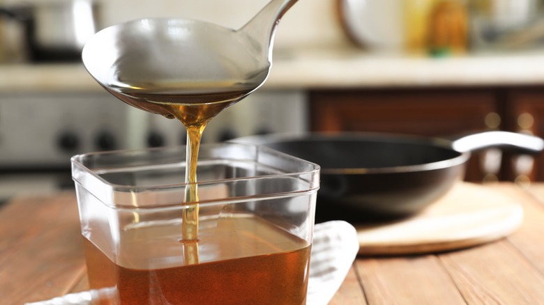 clarified cooking oil ladled into container