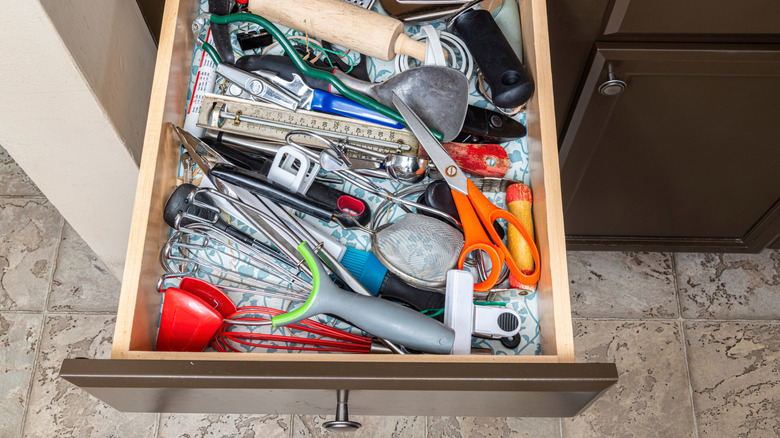 Kitchen drawer full of unorganized cooking utensils
