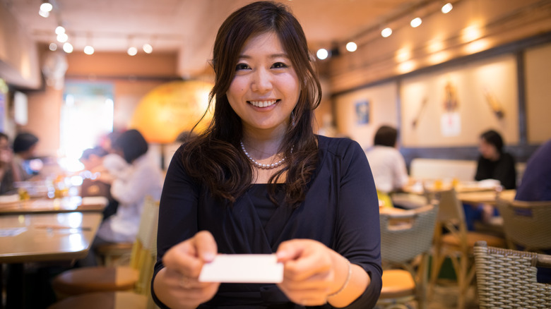 woman with business card in restaurant