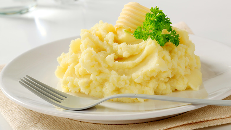 Plate of fluffy mashed potato with butter and parsley