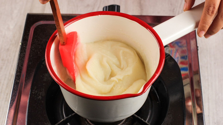 Stirring instant mashed potatoes on hob
