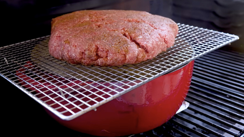 Beef smoking over a pot of chili.