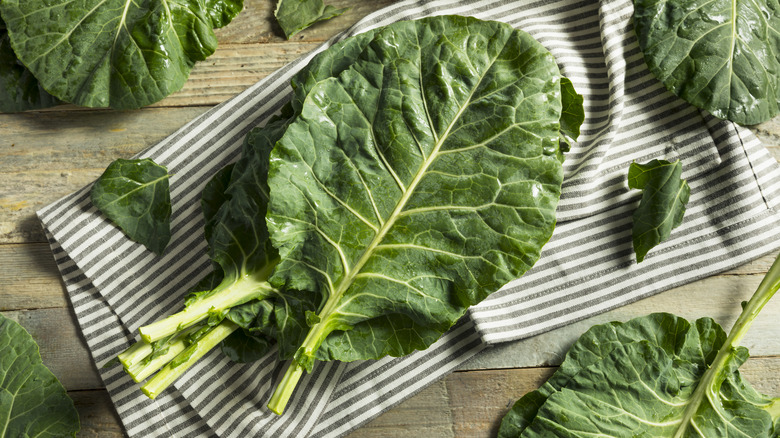 Raw collard green leaves on table