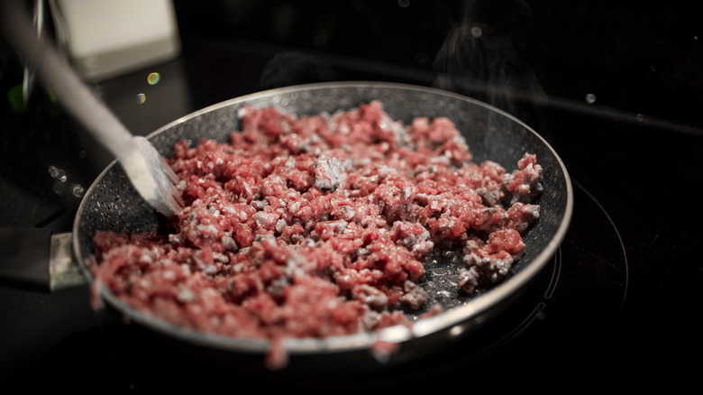 Cooking raw ground beef in a pan