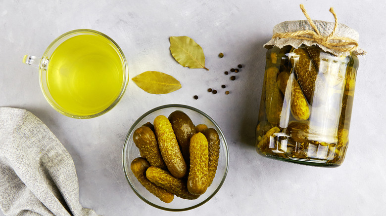 Jarred pickles and cup of pickle brine
