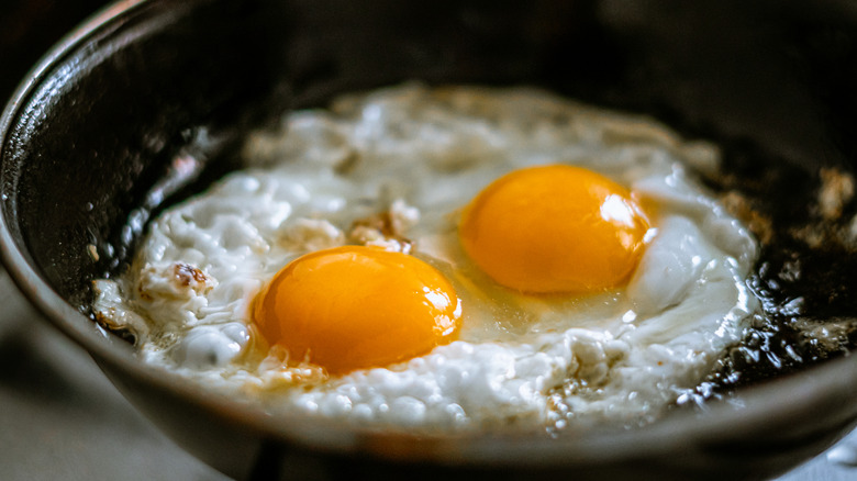 Two eggs frying in a pan.