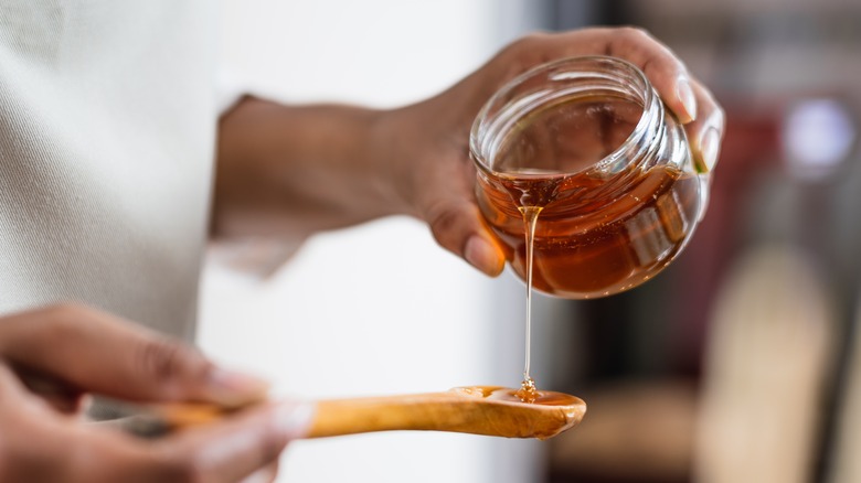 Pouring honey into spoon