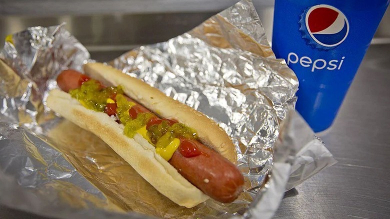 Costco food court hot dog with mustard, ketchup and relish and a blue Pepsi cup