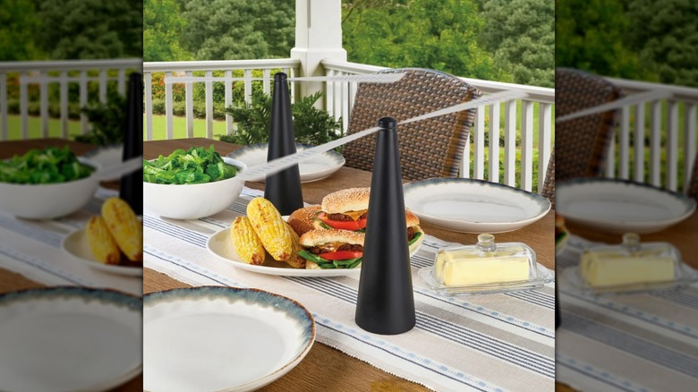 Two bug repelling fans on an outdoor dining table