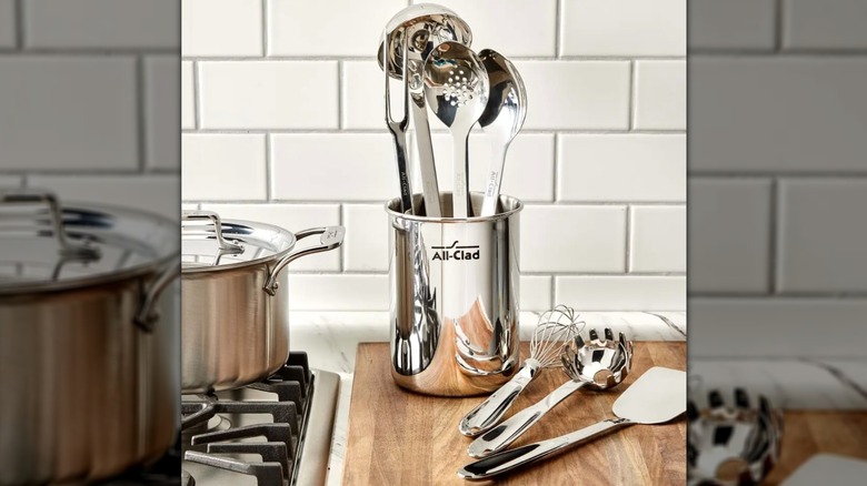 All-Clad stainless steel utensil set beside a stove