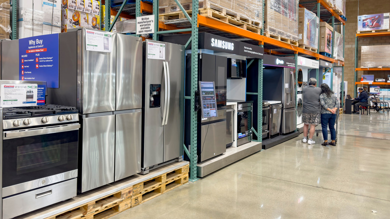 Shoppers looking at appliances in a Costco warehouse