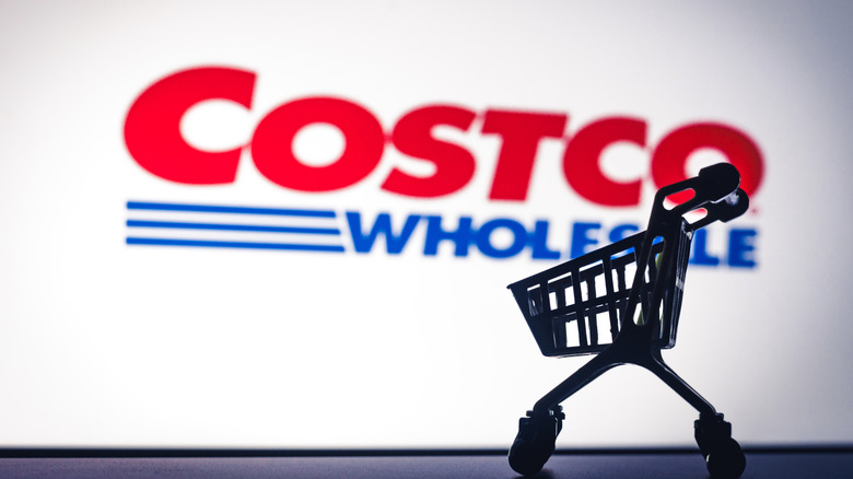Small shopping cart in front of a digital Costco display
