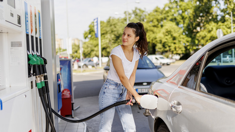 Woman refueling car at gas pump
