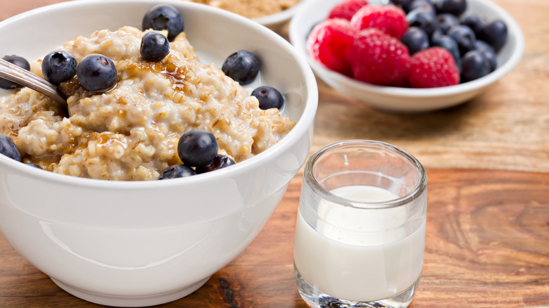 Bowl of creamy oatmeal with blueberries and honey