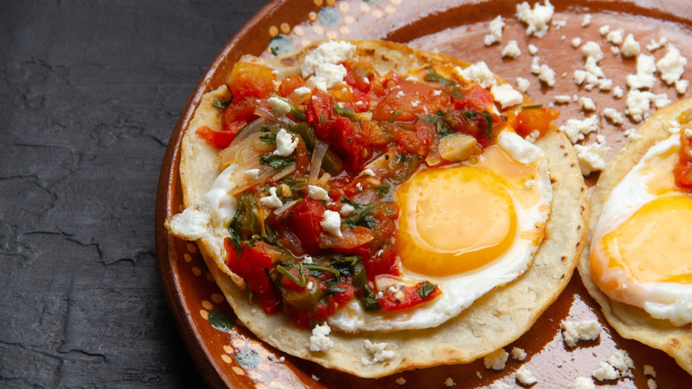 Huevos rancheros with sunny-side-up eggs on a Spanish-patterned plate