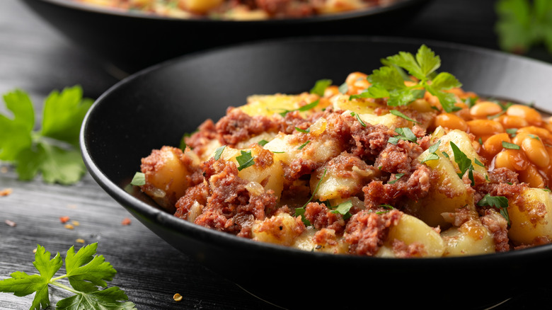 A Mexican hash with beans in a black bowl.