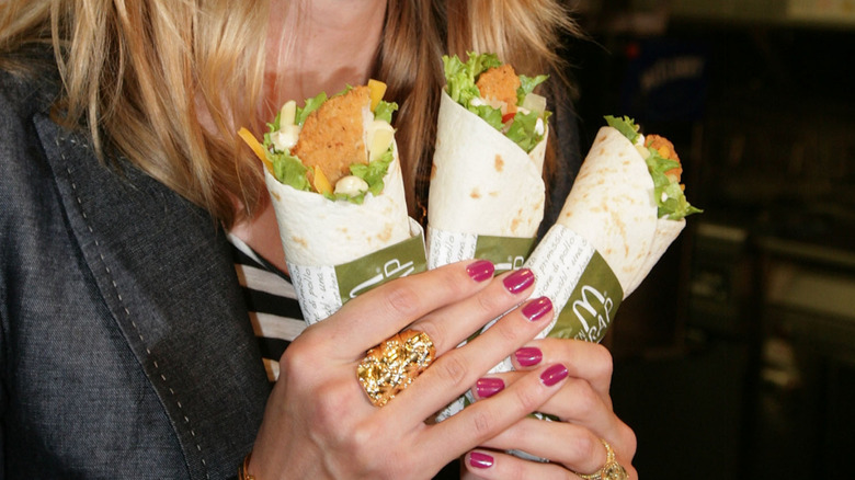 Supermodel Heidi Klum holds three McDonald's Snack Wraps at an event