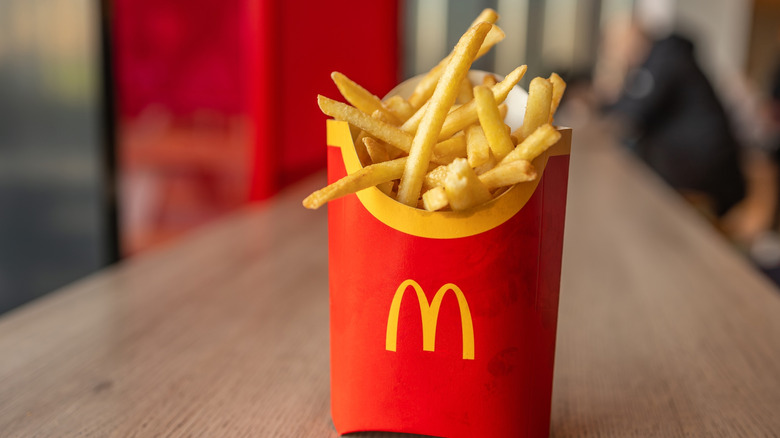 A container of McDonald's fries on a wooden table