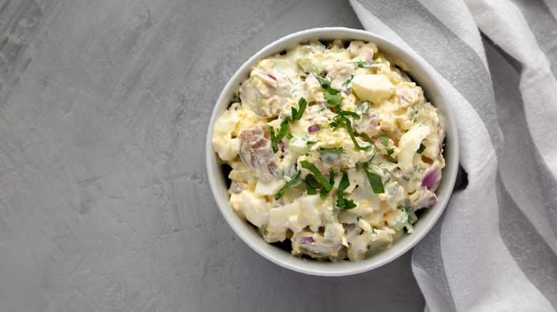Overhead view of creamy egg salad with fresh herbs