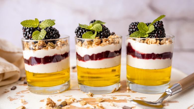 Glasses of lemon Jell-O dessert parfaits with fresh mint and blackberries
