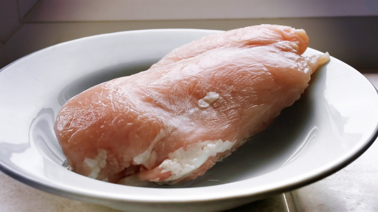 Chicken defrosting in white bowl