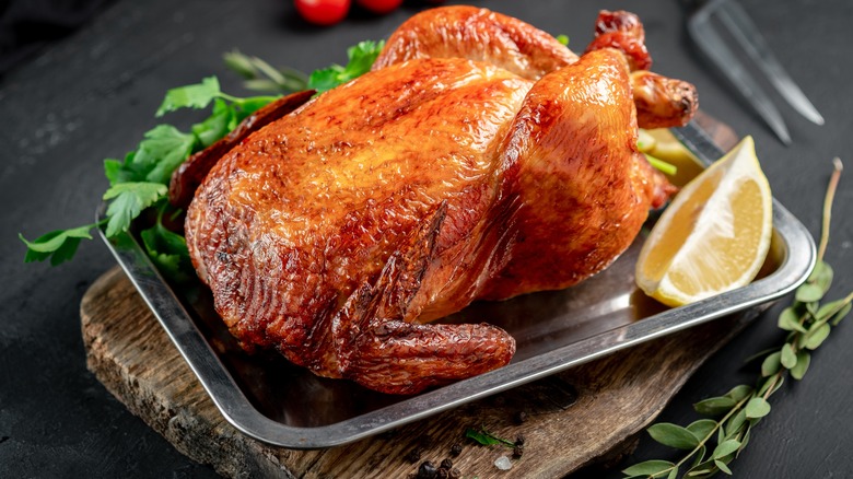 Whole cooked chicken on baking tray 