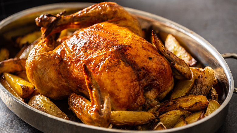 Whole roast chicken on potatoes
