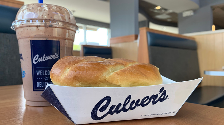 A Culver's sandwich sits next to a Culver's milkshake.