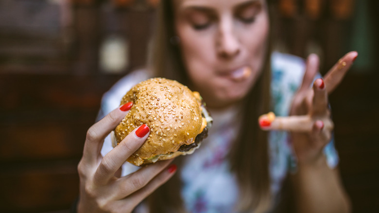 A diner enjoys a cheeseburger.