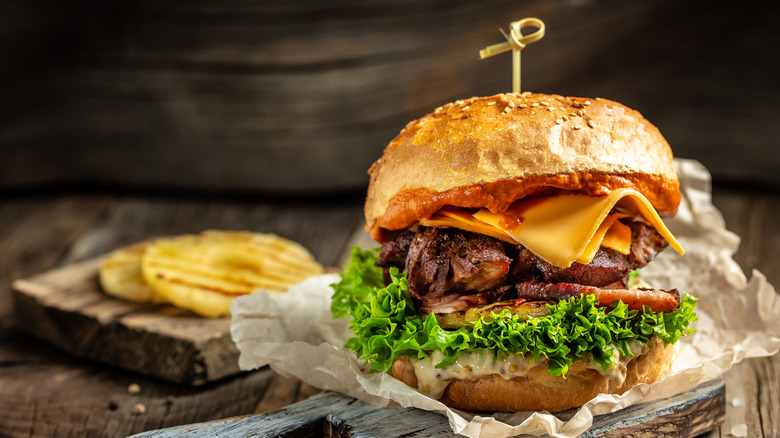 grilled bacon, cheeseburger on cutting board