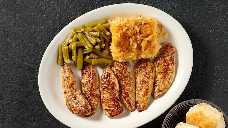 Cracker Barrel Grilled Chicken Tenders are laid atop a salad