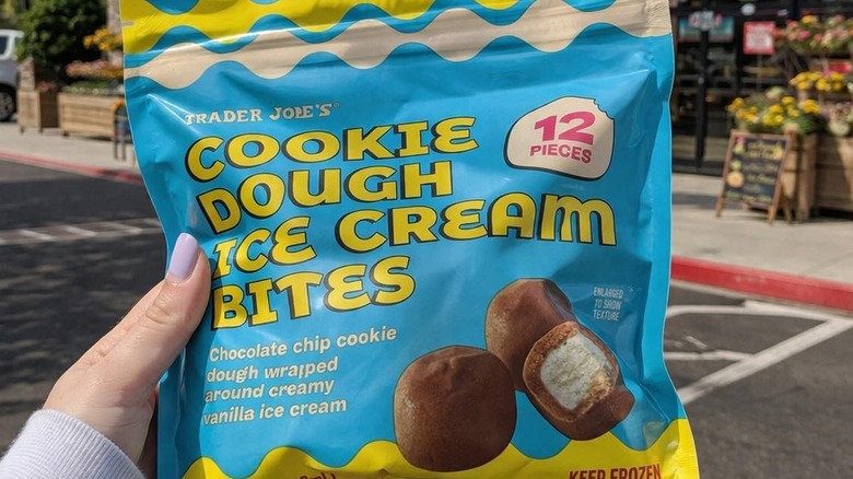 Hand holding bag of Trader Joe's Cookie Dough Ice Cream Bites