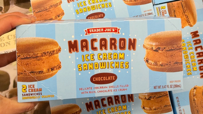 Hand holding a box of Trader Joe's Macaron Ice Cream Sandwiches